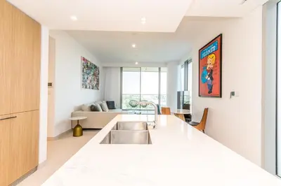 a kitchen with a sink and a living room at Luxury 3BDR Ellington House Dubai Hills in Dubai