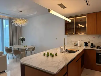 a kitchen with a white counter top and a table at 1 BR apartment in Ellington Beach House in Dubai