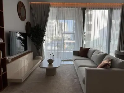 a living room with a couch and a tv and a table at 1 BR apartment in Ellington Beach House in Dubai