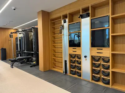 a fitness room with a gym with wooden walls at 1 BR apartment in Ellington Beach House in Dubai