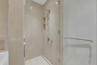 a shower with a glass door in a bathroom at Neat 3BR Habour Views with Balcony-Burj Khalifa View, Pool, Gym and Modern Facilities in Dubai