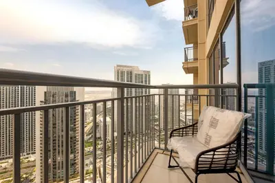 a balcony with a chair and a view of the city at Neat 3BR Habour Views with Balcony-Burj Khalifa View, Pool, Gym and Modern Facilities in Dubai