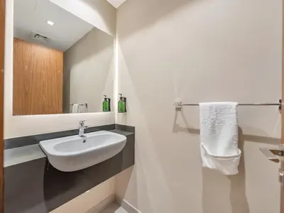 a bathroom with a white sink and a mirror at Livora Stays - Dubai Marina With Balcony & Water Views in Dubai