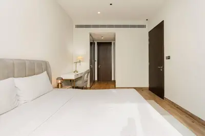 a bedroom with a large white bed and a desk at CitiHome - Stunning 5-Star Suite Jumeirah Living in Dubai