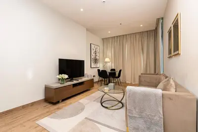a living room with a couch and a tv at CitiHome - Stunning 5-Star Suite Jumeirah Living in Dubai