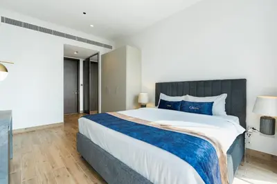 a bedroom with a large bed with blue pillows at CitiHome - Luxurious Marina View - Jumeirah Living in Dubai