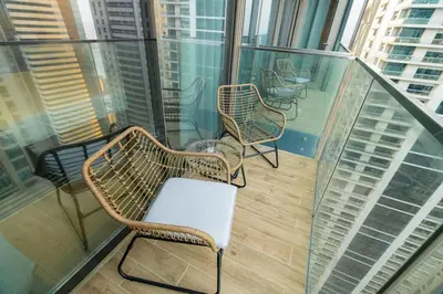 a balcony with chairs and tables on a building at CitiHome - Iconic 1BR Jumeirah Living Marina Gate in Dubai