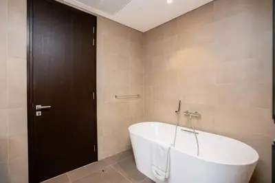 a bath tub in a bathroom with a black door at CitiHome - Iconic 1BR Jumeirah Living Marina Gate in Dubai