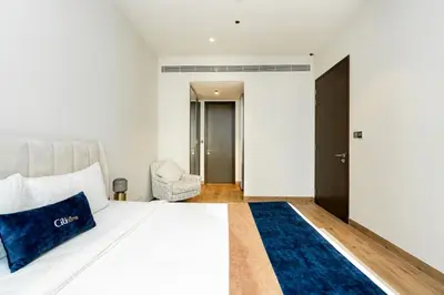 a bedroom with a white bed and a blue rug at CitiHome - Elegant Retreat in Dubai Marinas Heart in Dubai