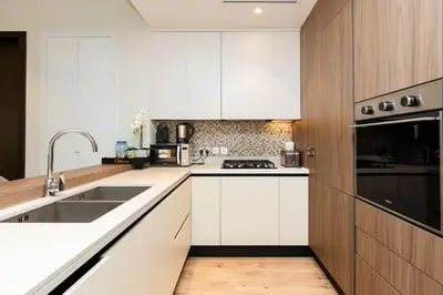 a kitchen with white cabinets and a sink at CitiHome - Elegant Retreat in Dubai Marinas Heart in Dubai