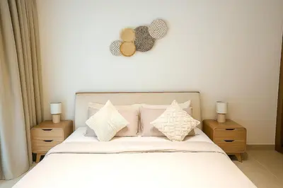 a bedroom with a bed with white sheets and pillows at 2BR Luxury, 2,5 bath, Baby bed, Gym & Pool in Dubai