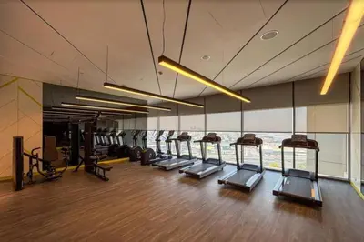 a gym with a row of treadmills in a building at 3 bedroom 51st floor Panoramic ocean views in Dubai