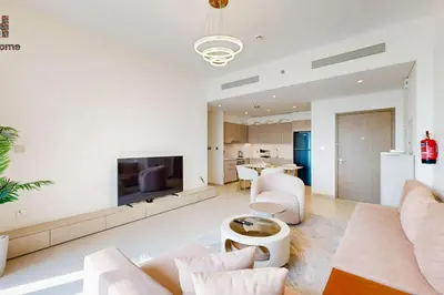 a living room with white furniture and a tv at Best Burj khalifa View 2 Mins Dubai Mall Like home in Dubai