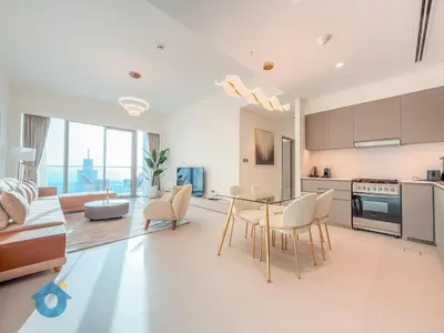 a kitchen and living room with a table and chairs at Next to Burj Khalifa - Skyline Balcony Like home in Dubai