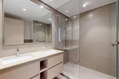 a bathroom with two sinks and a glass shower at NEXT TO DUBAI MALL AND BURJ 2 BR SEA VIEW in Dubai