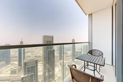 a balcony with a table and chairs looking out at the city at NEXT TO DUBAI MALL AND BURJ 2 BR SEA VIEW in Dubai