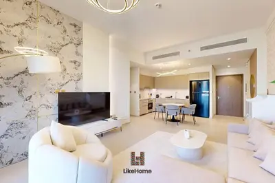 a living room with a white couch and a television at NEXT TO BURJ AND DUBAI MALL 2 BR BEST LOCATION in Dubai