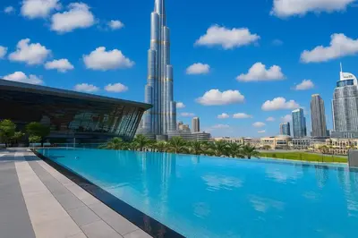 a large swimming pool in front of a city skyline at NEXT TO BURJ AND DUBAI MALL 2 BR BEST LOCATION in Dubai
