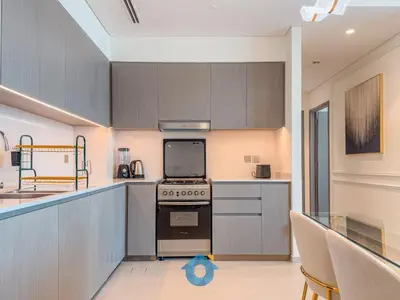 a kitchen with gray cabinets and a stove top oven at Direct Burj Khalifa View Near Dubai Mall Like Home in Dubai