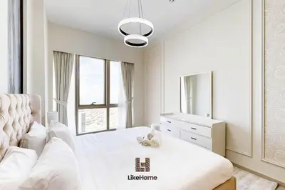 a white bedroom with a white bed and a large window at DIRECT BURJ KHALIFA ONLY 2 MINUTES AWAY in Dubai