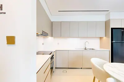 a white kitchen with white cabinets and a sink at DIRECT BURJ KHALIFA ONLY 2 MINUTES AWAY in Dubai