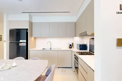 a kitchen with white cabinets and a table with chairs at NEXT TO BURJ KHALIFA AND DUBAI MALL ONLY 2 MINUTES AWAY in Dubai