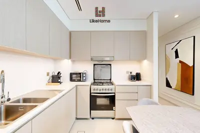 a kitchen with white cabinets and a stove top oven at NEXT TO BURJ KHALIFA AND DUBAI MALL ONLY 2 MINUTES AWAY in Dubai