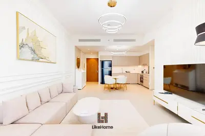 a living room with a white couch and a kitchen at BEST LOCATION 2 MINUTES AWAY FROM BURJ KHALIFA in Dubai