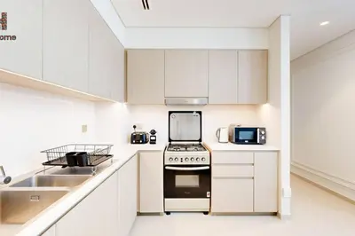 a white kitchen with a stove and a sink at BEST LOCATION 2 MINUTES AWAY FROM BURJ KHALIFA in Dubai