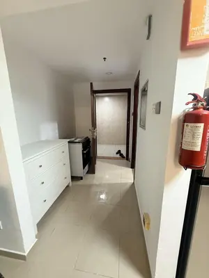 a hallway with a room with a kitchen and a stove at Cozy Studio Apartment in JCV in Dubai