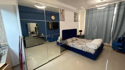 a small room with a bed and a mirror at Cozy Studio Apartment in JCV in Dubai