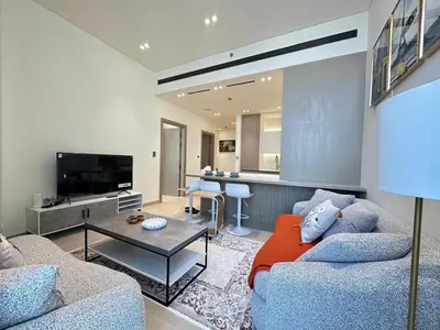 a living room with two couches and a table at Luxury 1BR - Private Balcony Pool & Smart Home - Binghatti Phantom JVC in Dubai