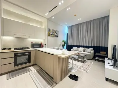 a kitchen and a living room with a couch at Luxury 1BR - Private Balcony Pool & Smart Home - Binghatti Phantom JVC in Dubai