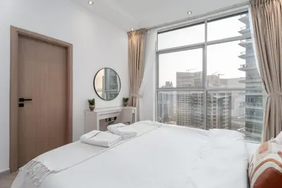 a bedroom with a large white bed and a large window at Gala Guests - Signature Skyview Tower High-Floor Marina Living in Dubai