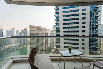 a balcony with a table and chairs and a view of the city at Gala Guests - Signature Skyview Tower High-Floor Marina Living in Dubai