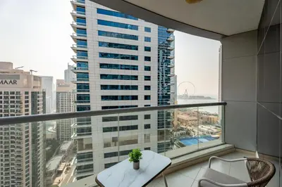 a balcony with a table and chairs and a large window at Gala Guests - Signature Skyview Tower High-Floor Marina Living in Dubai