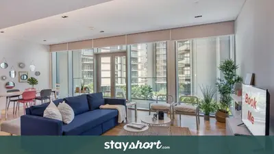 a living room with a blue couch and a table at StayShort - Bluewaters Finest Elegant 1BR Apartment - Beach Lifestyle in Dubai