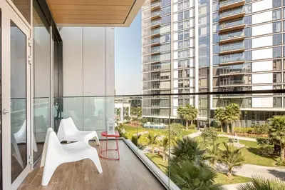 a balcony with white chairs and a view of a building at StayShort - Bluewaters Finest Elegant 1BR Apartment - Beach Lifestyle in Dubai