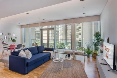 a living room with a blue couch and a table at StayShort - Bluewaters Finest Elegant 1BR Apartment - Beach Lifestyle in Dubai