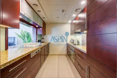 a kitchen with wooden cabinets and a sink at Aspin Stylish Burj Views Studio-City View in Dubai