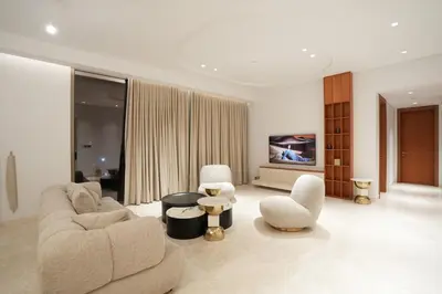 a living room with a couch and chairs and a tv at Spacious 2BR Near Beach Ellington in Dubai