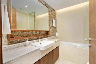 a bathroom with a sink and a mirror at Imperial Avenue Downtown Lux 1Bed with Balcony in Dubai