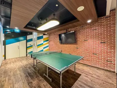 a ping pong table in a room with a brick wall at Imperial Avenue Downtown Lux 1Bed with Balcony in Dubai