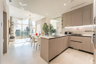 a kitchen with brown cabinets and a dining room at Community View, Near the Circle Mall, Pear House II by Imtiaz, Jumeirah Village Circle by Deluxe Holiday Homes in Dubai