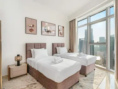 two beds in a hotel room with a window at Luxurious 3-bedroom apartment downtown in Dubai