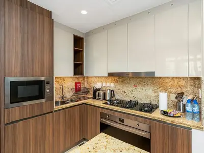 a kitchen with white cabinets and a microwave at Luxurious 3-bedroom apartment downtown in Dubai