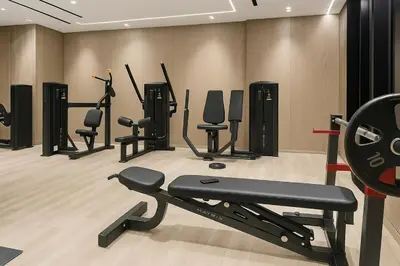 a gym with several exercise equipment in a room at Cozy 1-Bedroom Flat in Central JVC in Dubai
