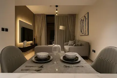 a living room with a dining table and a living room at Cozy 1-Bedroom Flat in Central JVC in Dubai