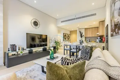 a living room with a couch and a table at Balcony-Facing Pool 2BR with Assistant Room, Minutes Walk to Park, Miracle and Butterfly Garden, Divine Living, Arjan by Deluxe Holiday Homes in Dubai