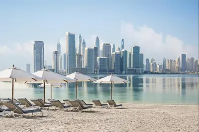 a group of chairs and umbrellas on a beach at Palm Home next to Nakheel Mall with Private Beach in Dubai